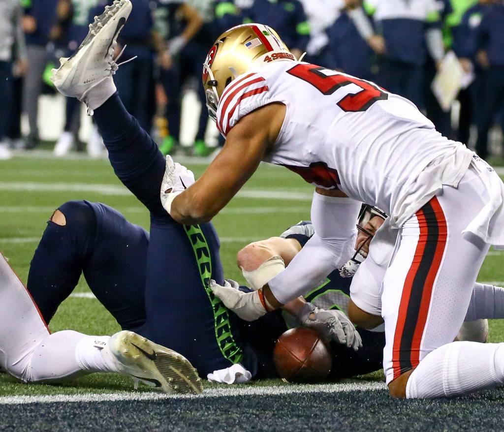 Seattle Seahawks Jacob Hollister is stopped inches from the goal line by San Franciscos Fred Warner Sunday evening at CenturyLink Field in Seattle on December 29, 2019. The 49ers won 26-21. (Kevin Clark / The Herald)
