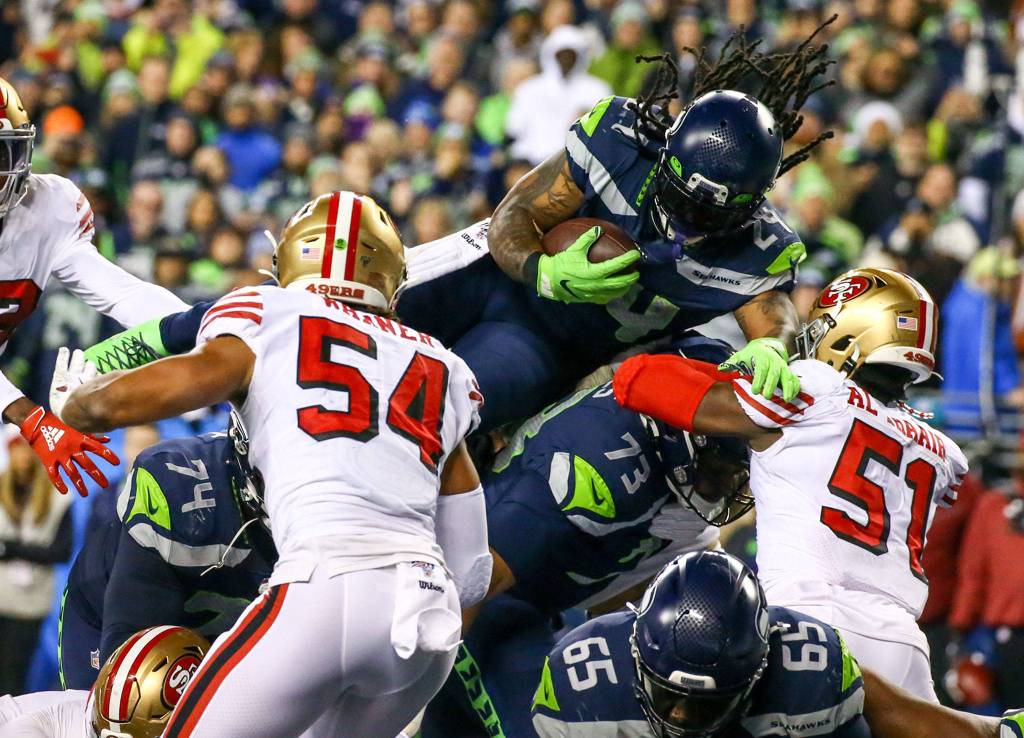 Seattle Seahawks Marshawn Lynch leaps the line for a touchdown against the 49ers Sunday evening at CenturyLink Field in Seattle on December 29, 2019. The 49ers won 26-21. (Kevin Clark / The Herald)