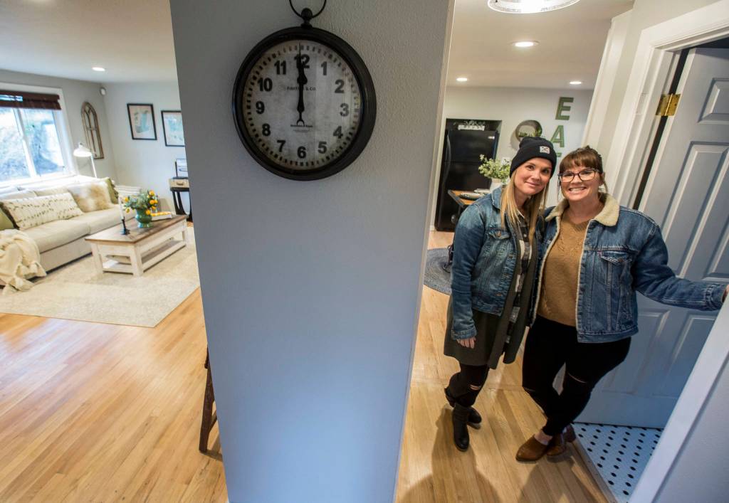 Snohomish twin sisters Lyndsay Lamb, right, and Leslie Davis pose inside one of their local remodeled homes that will be on their new HGTV series Unsellable Houses, which starts Feb. 4. This home in Everett went on the market last week. (Olivia Vanni / The Herald)