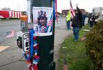 A photo of Samiu Bloomfield is taped to a pole where his friends and fans gather on Broadway to wave in his honor Monday in Everett. (Andy Bronson / The Herald)