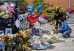 People place flowers at a memorial in front of Bothell City Hall on Tuesday for Officer Jonathan Shoop, who was killed in the line of duty Monday night. (Olivia Vanni / The Herald)