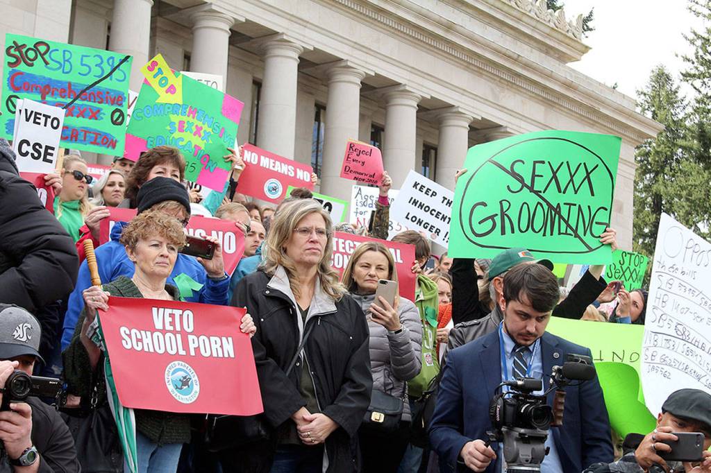 Dissatisfied residents hold signs in protest of comprehensive sex education mandate earlier this year. WNPA News Service