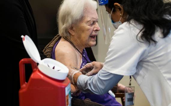 Jackie Hoernor winces as she gets her Pfizer COVID-19 vaccination during a Walgreens Vaccine Clinic at South Pointe on Friday, Feb. 12, 2021, in Everett, Washington. (Sound Publishing file photo)