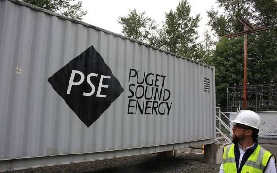 In this 2019 file photo, Puget Sound Energy product development manager John Dooley stands in front of one of four units at the Glacier Battery Storage Project in northwest Washington state. (Sound Publishing file photo)