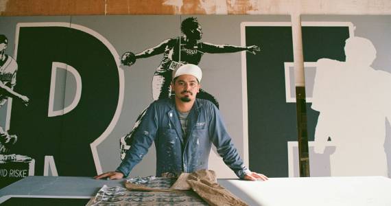 Alexander Codd poses in front of the Liberty Park mural (photo by Andrew Valantine)