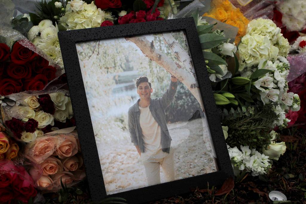 Dozens of flower bouquets and candles placed at the site of Ruvim Stukovs memorial in Federal Way on Dec. 10, 2021. Olivia Sullivan/the Mirror