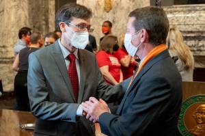Washington Attorney General Bob Ferguson (left) speaks with Paul Kramer at the signing of bills aimed at reducing gun violence Wednesday in Olympia. Kramers son Will was injured in a 2016 mass shooting in Mukilteo that left three people dead. (Washington State Attorney General)