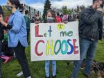 A young girl holds a sign saying Let me choose during a reproductive rights protest at Cal Anderson Park on May 14, 2022. Hannah Saunders/Sound Publishing