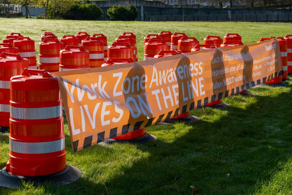 Sixty-one orange traffic barrels were set up April 2, 2024, on the WSDOT front lawn in Olympia. Each cone represents a fallen WSDOT employee killed on the job since 1950 - many in active work zones. The visual display is meant to remind everyone of the importance of slowing down in work zones. Photo courtesy of Washington State Department of Transportation.