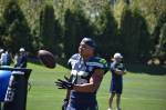 Seattle Seahawks Running Back Zach Charbonnet tosses a ball to a Seahawks coach. Ben Ray / Sound Publishing