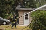 Photo by Allyson Ballard. A firefighter from Central Whidbey Island Fire and Rescue sprayed the neighboring home.