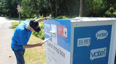A man places his ballot into the drop box outside Federal Way City Hall. Bailey Jo Josie/Sound Publishing