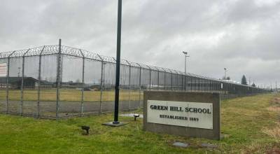 A sign and fence at the Green Hill School for juvenile offenders, in Chehalis, Washington. (Photo by Jake Goldstein-Street/Washington State Standard)